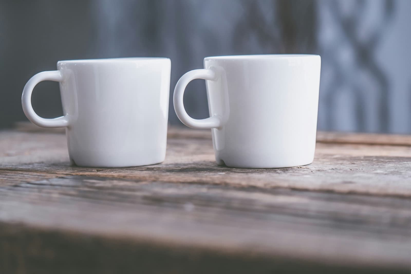 Two white mugs on a wooden table